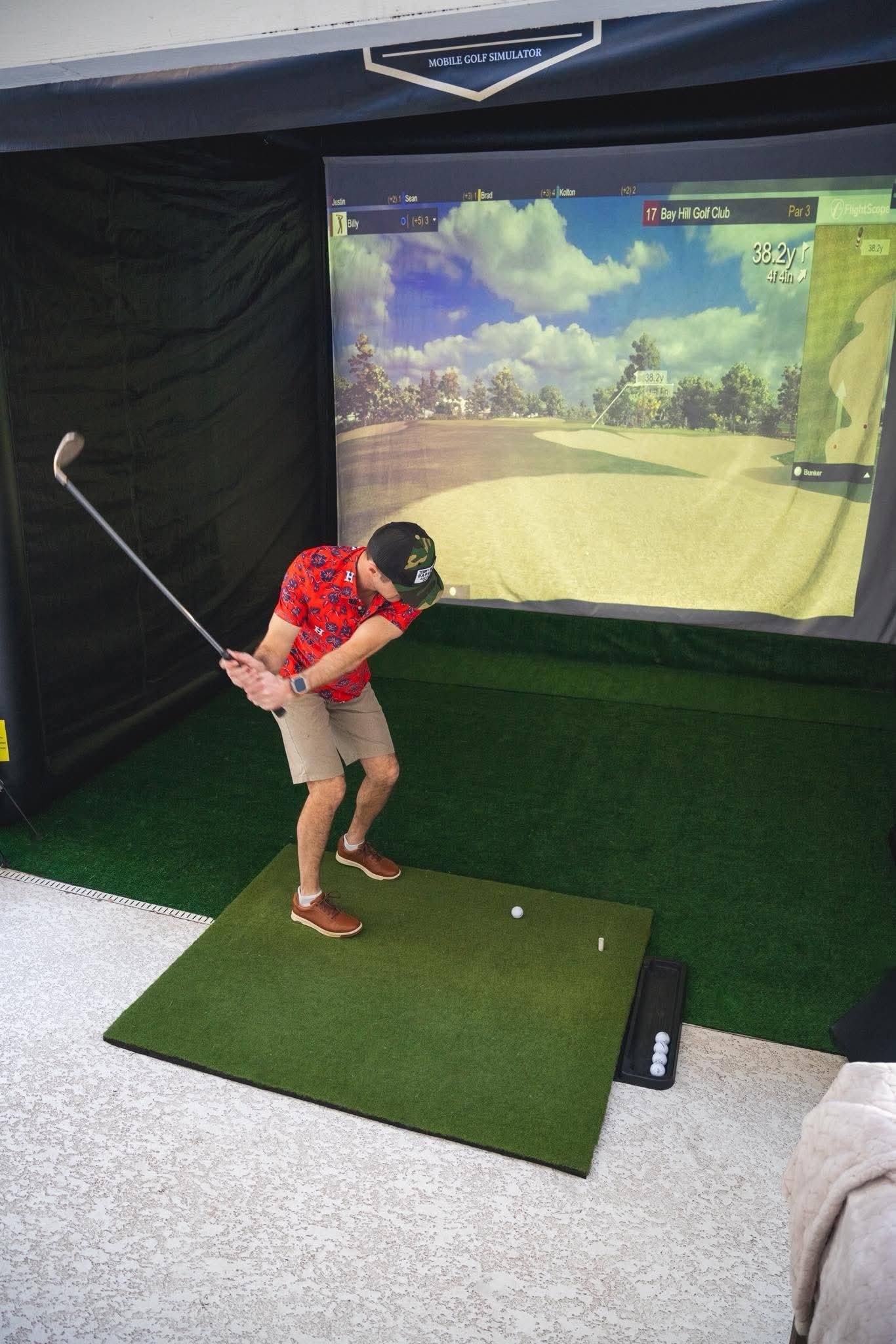 Guest playing the mobile golf simulator indoors